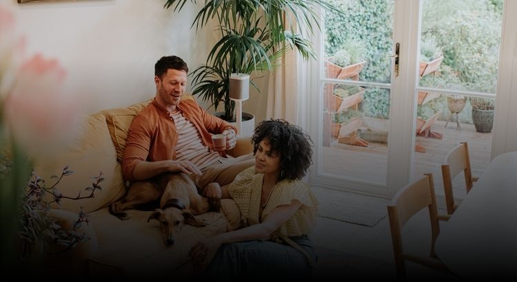 Couple sitting on couch with a dog
